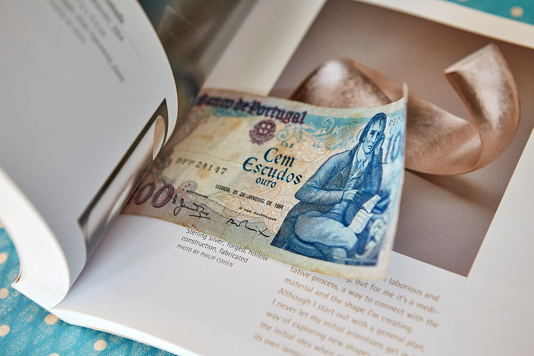 The banknote being placed into a book to be pressed.